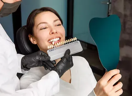 Dentist matching tooth shades with a patient before dental bonding