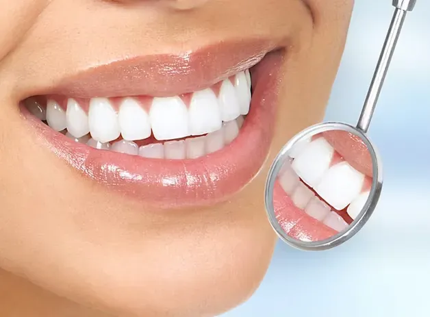 Bright, healthy smile reflected in a dental mirror after a teeth cleaning